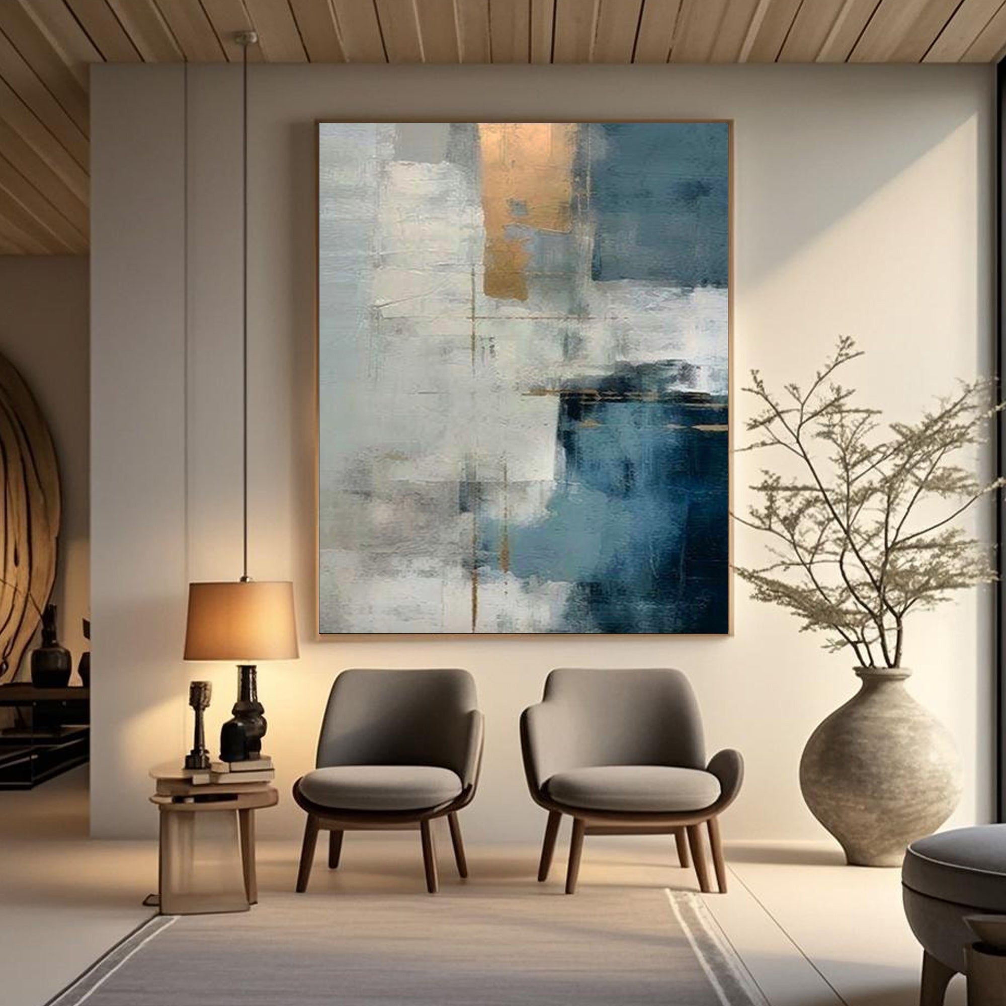 Large minimalist abstract painting with textured blue, white, and gold brushstrokes, titled 'Blue Threshold', displayed in a modern living room with gray chairs and a wooden side table.