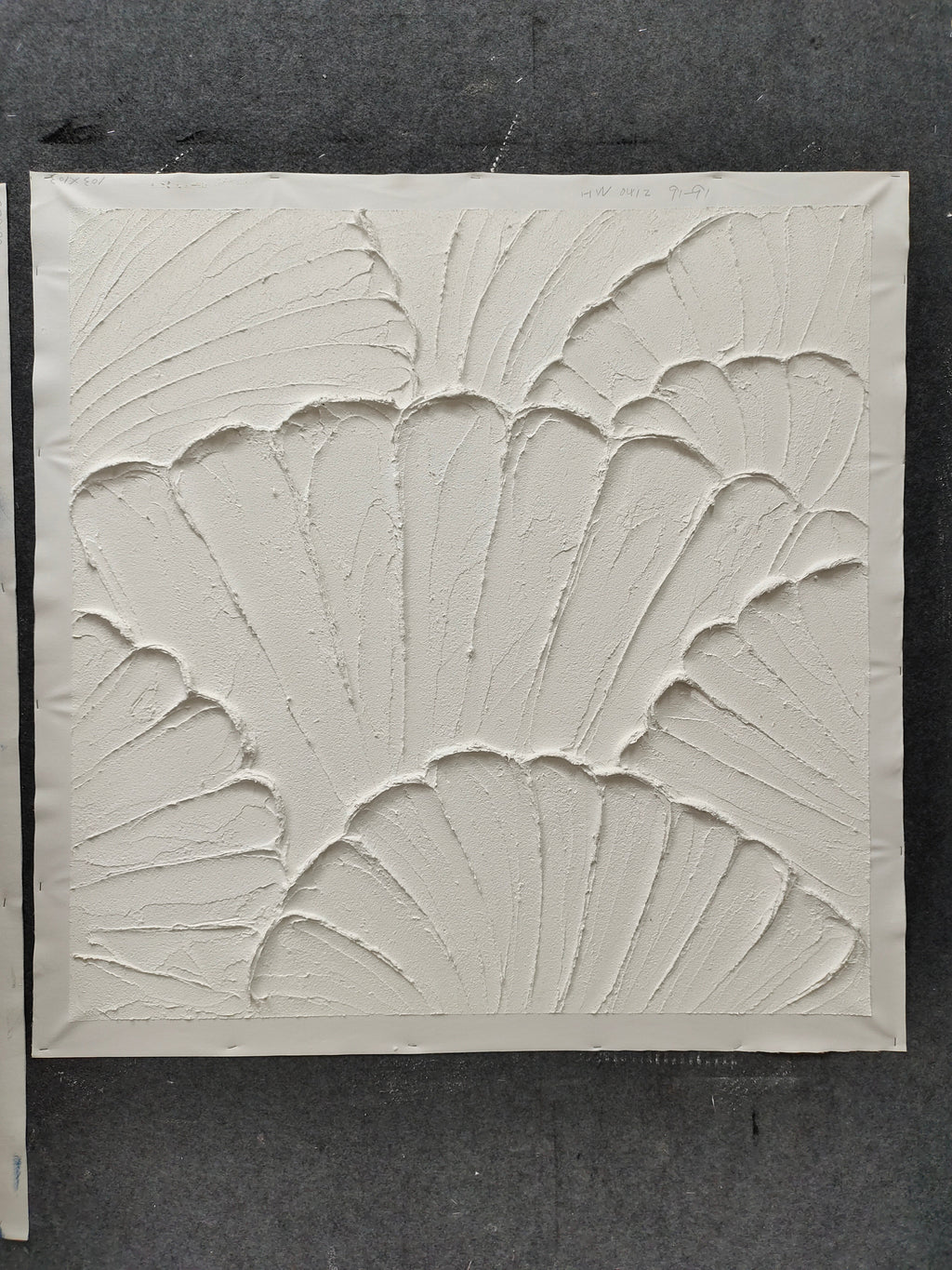 White plaster art texture painting above a chair in a styled room.