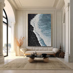 Textured ocean canvas art above sofa in bright living room.