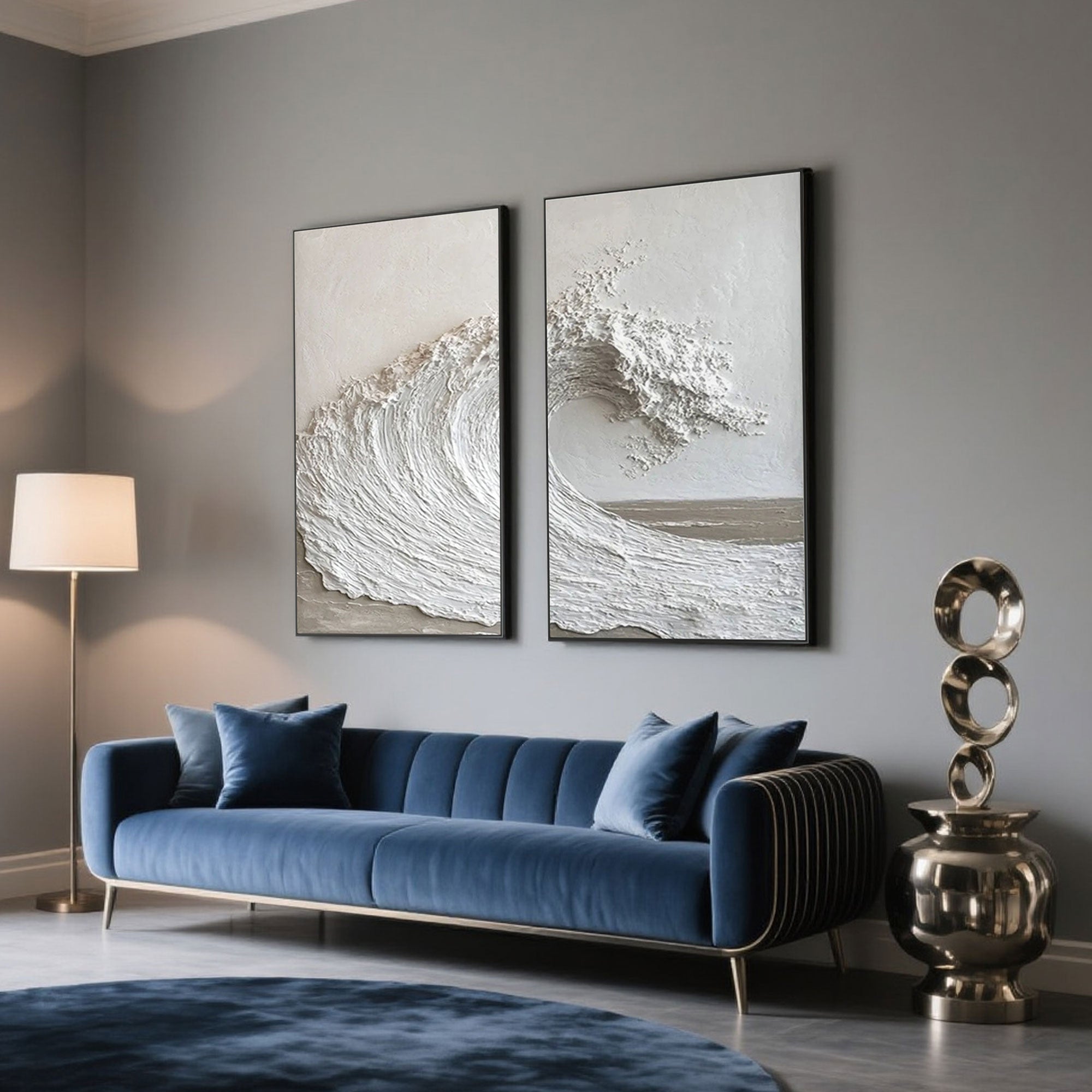 Textured ocean wave art in black frames above blue velvet sofa.