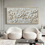 Modern living room featuring 3D floral beige wall art above white chairs.