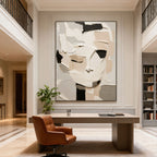 3D textured abstract portrait canvas art 'Silent Self' with thick layered brushstrokes in neutral tones of white, beige, black, and gray, displayed in a modern office with a desk and leather chair.