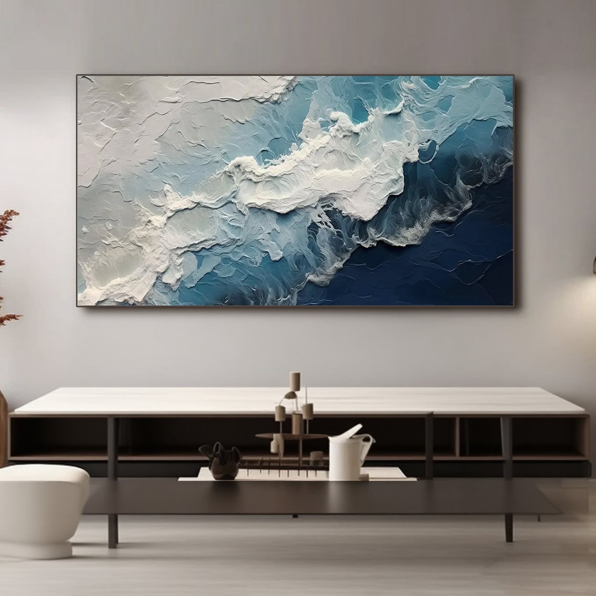 Modern ocean wave art above console table in living room setting.