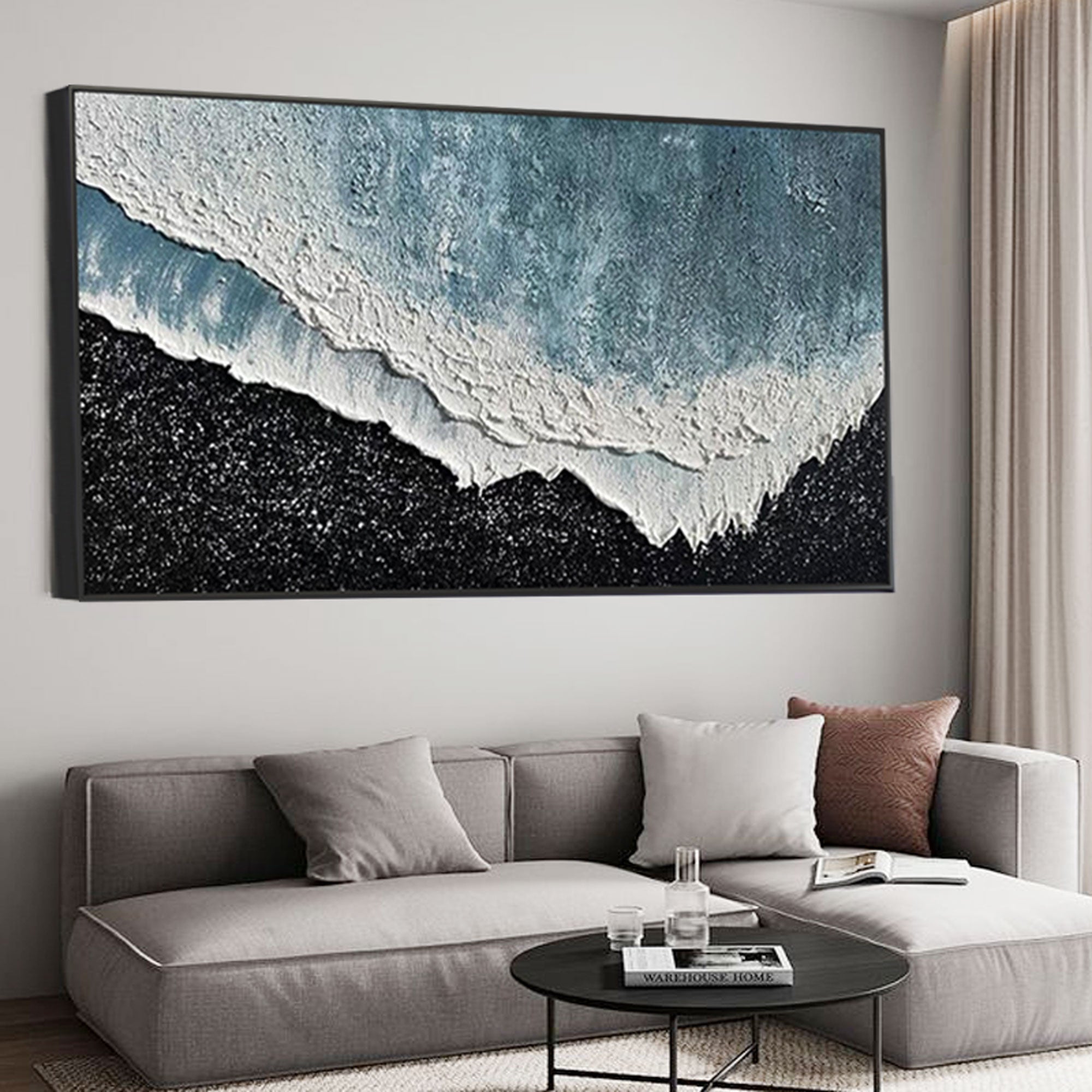 3D textured ocean canvas art with black frame above grey sofa.