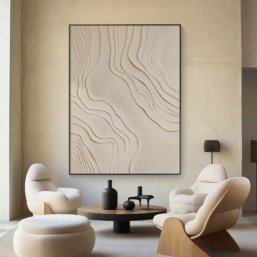 Modern living room with abstract wall art, beige chairs, and a round coffee table.