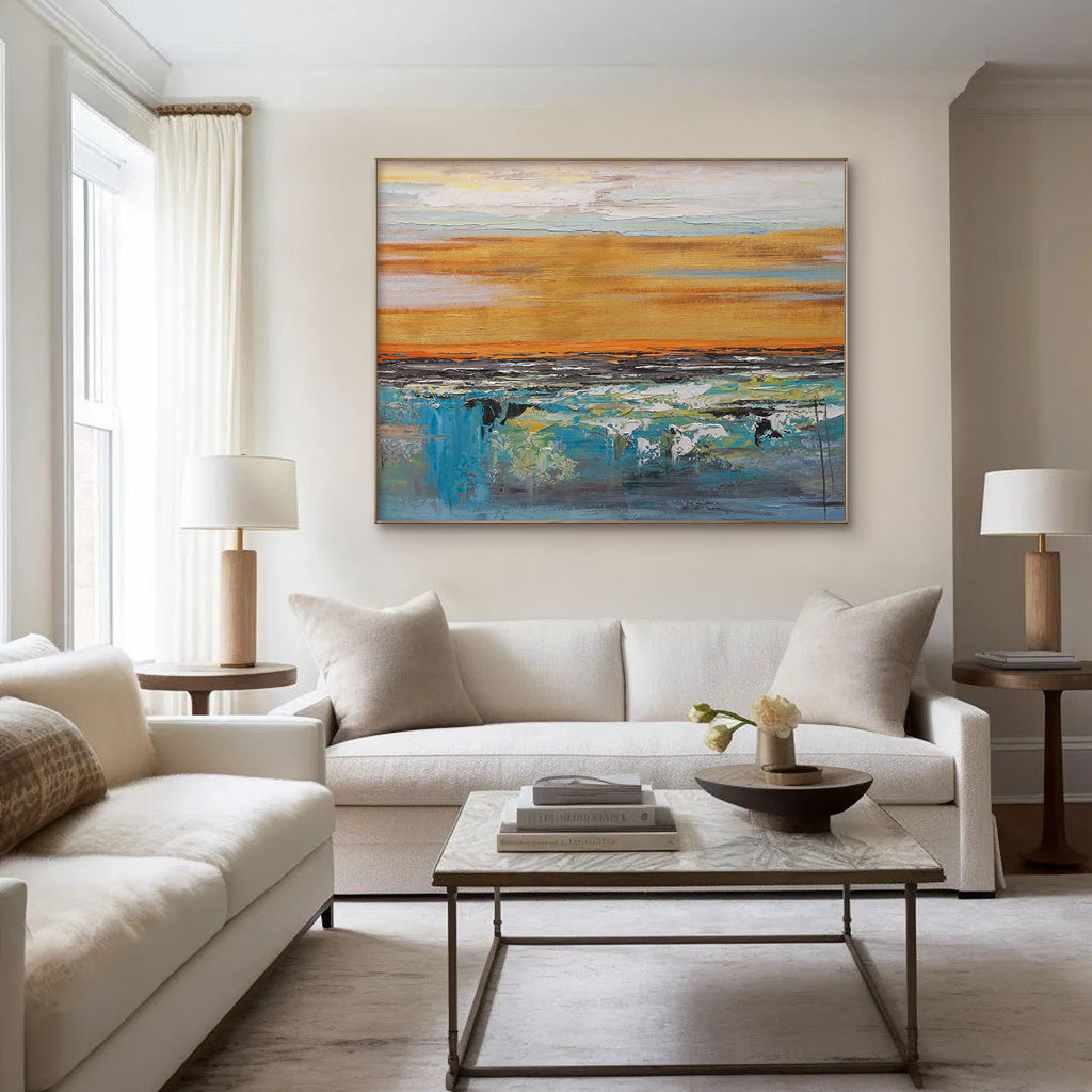 Abstract landscape art in living room. Golden and blue canvas above a white sofa.