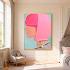 Abstract modern portrait wall art with soft pink and peach profile against light blue background, gold frame, textured brushstrokes, displayed in bright bedroom with natural light.