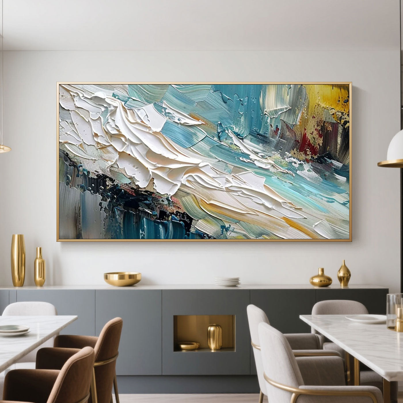 Abstract minimalist wave wall art 'Tidal Burst' with textured teal, white, and yellow brushstrokes in a gold frame, displayed in a modern dining room with gray cabinets and gold accents.