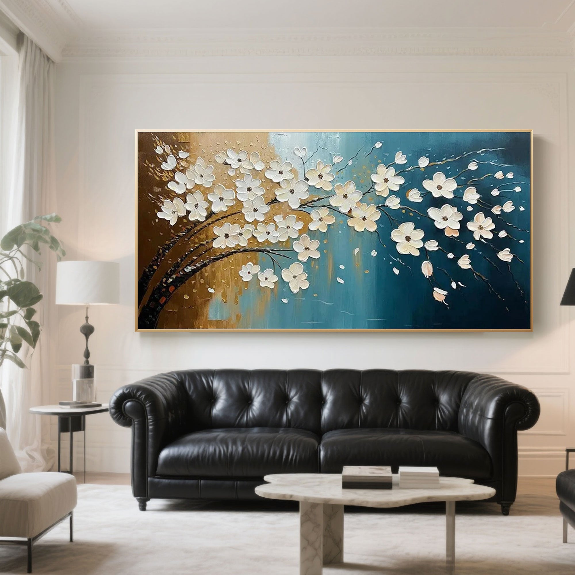 Virelia floral wall art with gold frame above a classic black leather sofa.