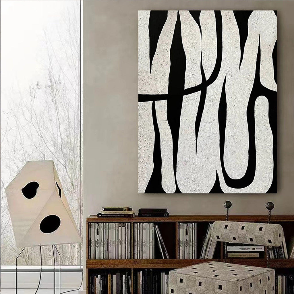 Black and white abstract line art, showcasing minimalist style, with black lines weaving across a white background, adding an artistic touch to modern interiors.
