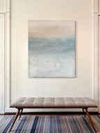 Abstract landscape painting with soft blue, beige, and white tones, creating a calming atmosphere.