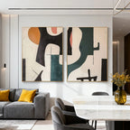 Two mid-century geometric abstract paintings with bold shapes in orange, black, teal, pink, and beige, featuring textured details, displayed in a modern living room with a gray sofa and marble dining table.