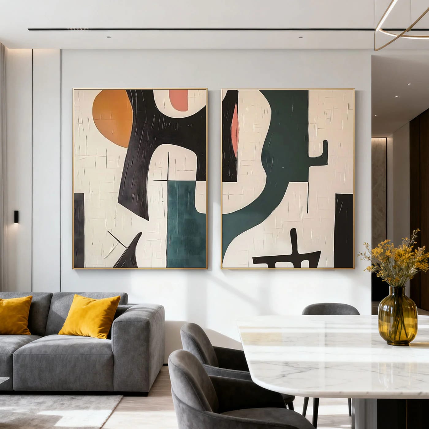 Two mid-century geometric abstract paintings with bold shapes in orange, black, teal, pink, and beige, featuring textured details, displayed in a modern living room with a gray sofa and marble dining table.