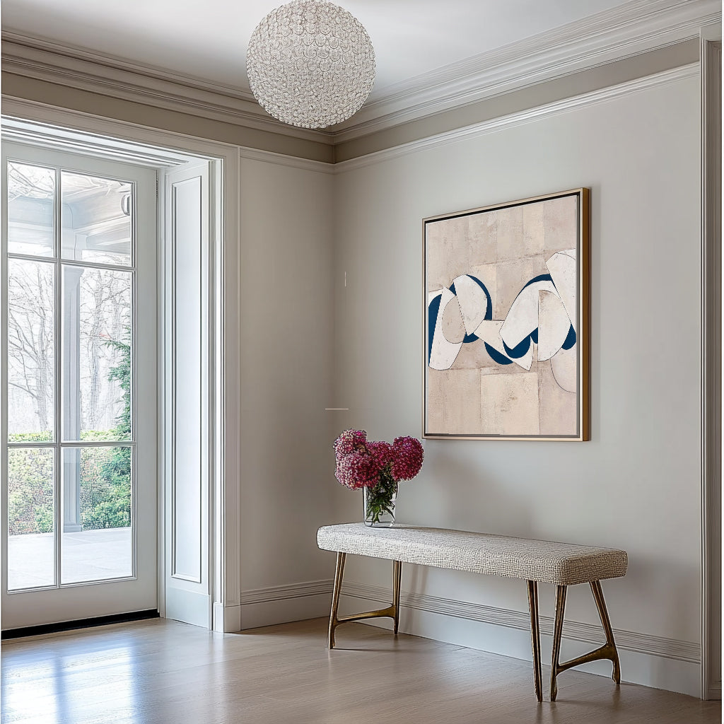 Beige geometric canvas art with blue accents in a staged living room.
