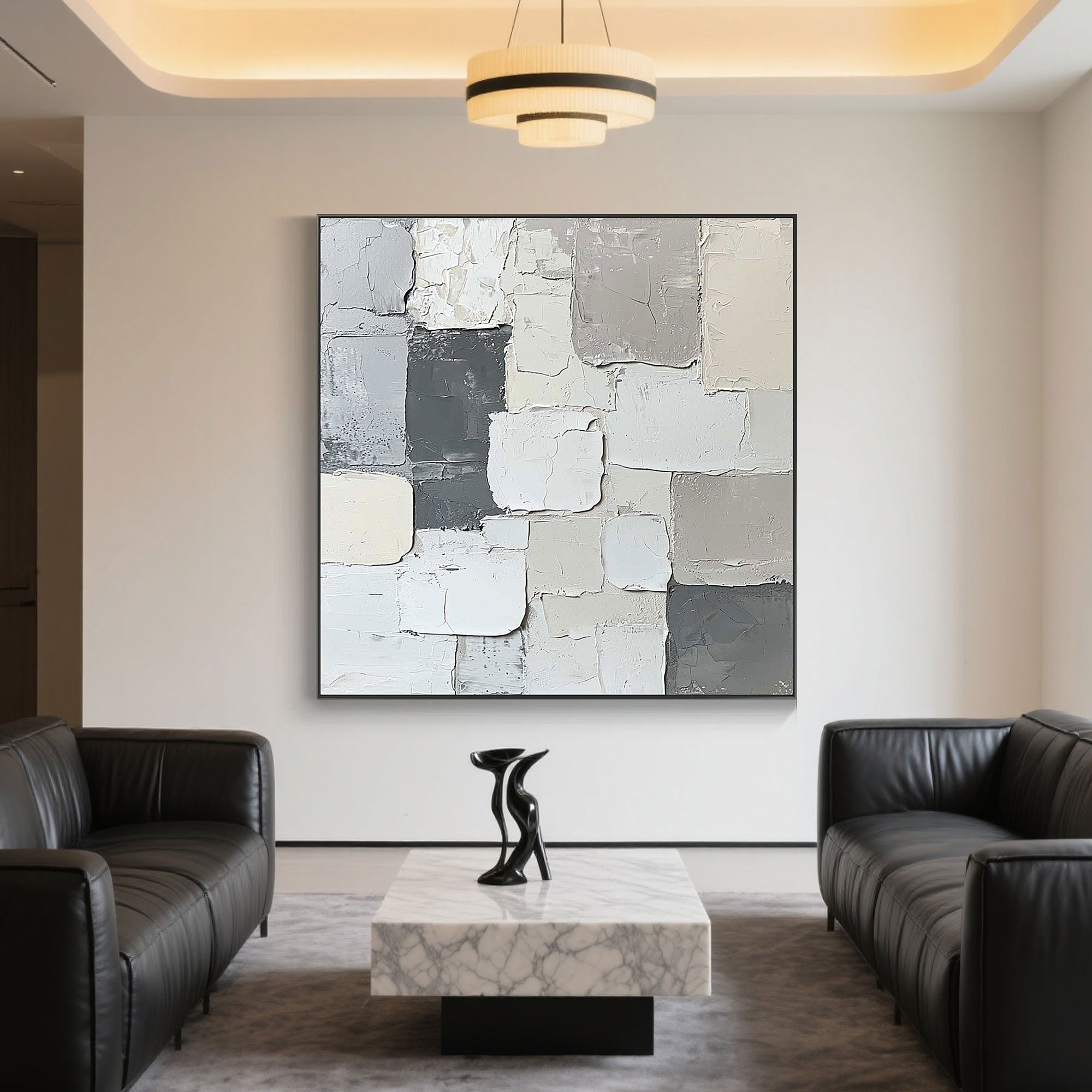 Minimalist abstract canvas art displayed above a marble table in a modern living room.