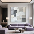 Minimalist abstract canvas art in a modern living room with a purple sofa.