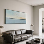 Abstract seascape canvas art with black frame in a modern living room.