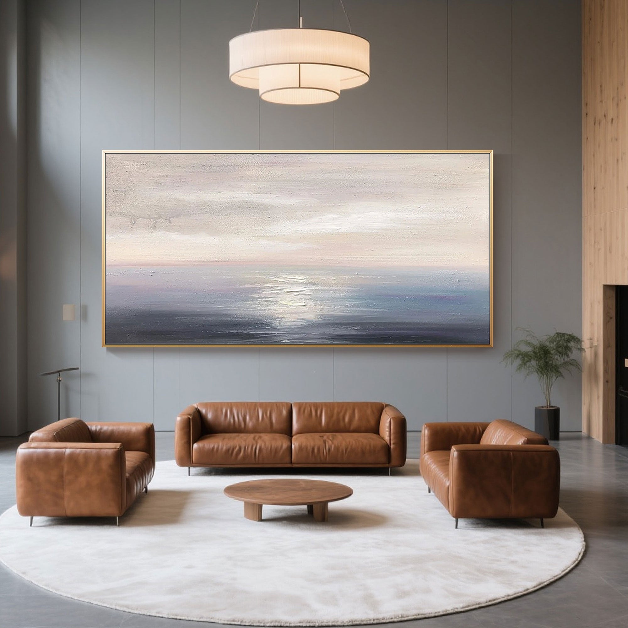 Abstract seascape painting hanging above brown leather living room set.