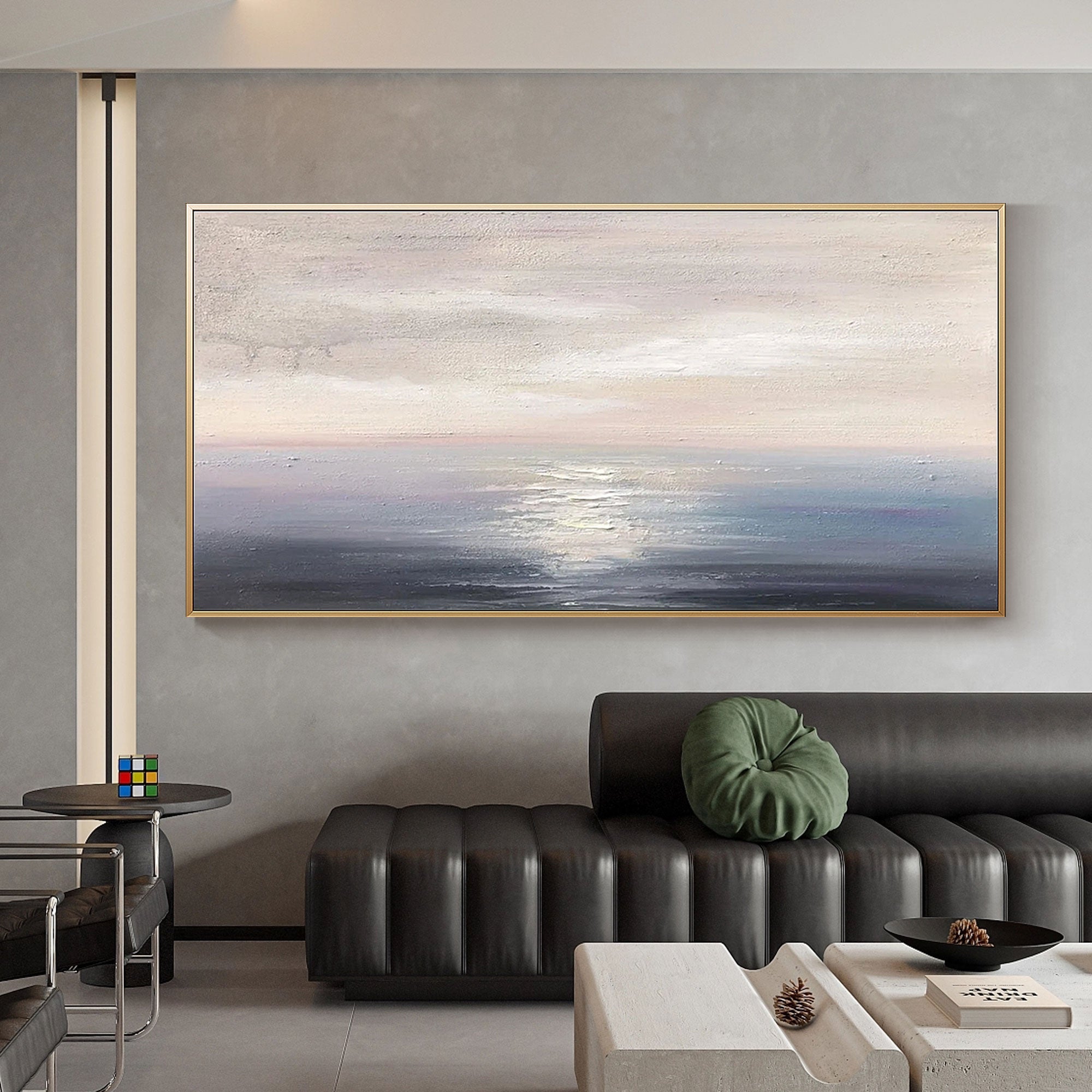Minimalist seascape art with gold frame in modern living room.