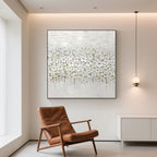 White bloom floral wall art hanging above a cabinet, next to a brown leather chair.