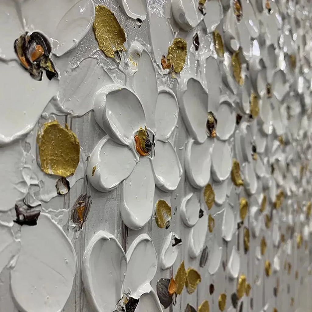 Close-up of white floral art with gold accents in a sleek black frame.