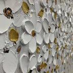 Close-up of white floral art with gold accents in a sleek black frame.