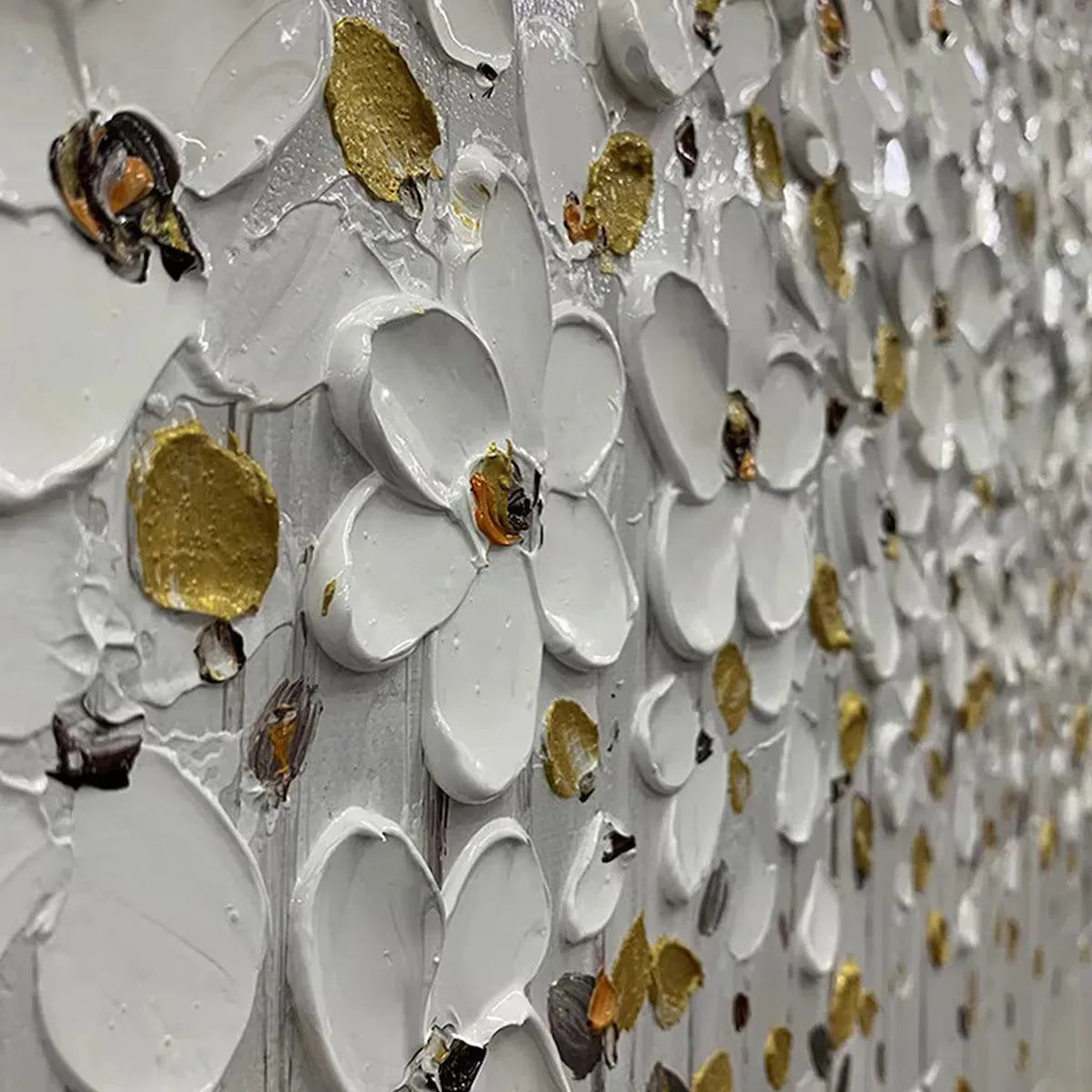 Close-up of white floral art with gold accents in a sleek black frame.