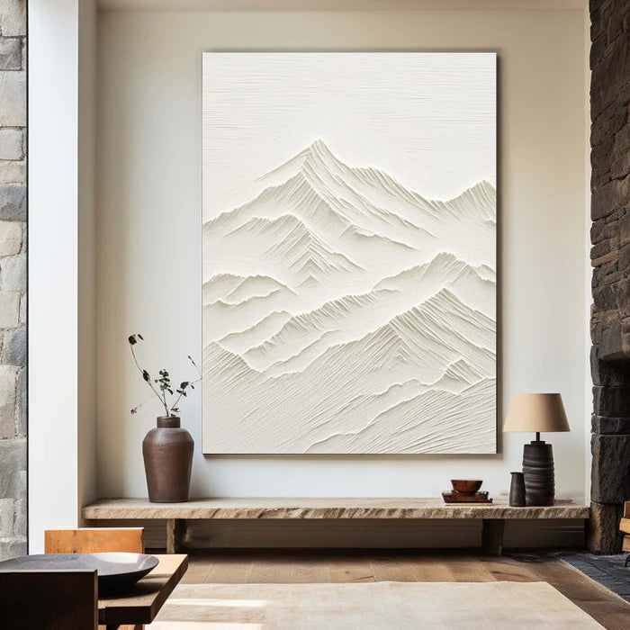 Textured mountain art above console table in living room setting.