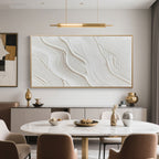 Beige and white wave art in gold frame above a dining table.
