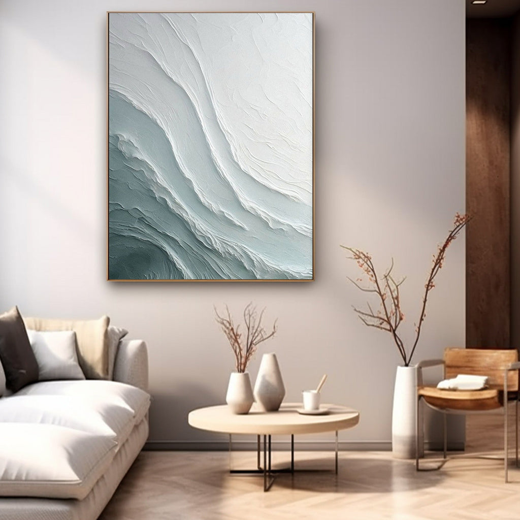 Modern lounge featuring textured blue-white artwork, metal-rimmed table and floor lamp