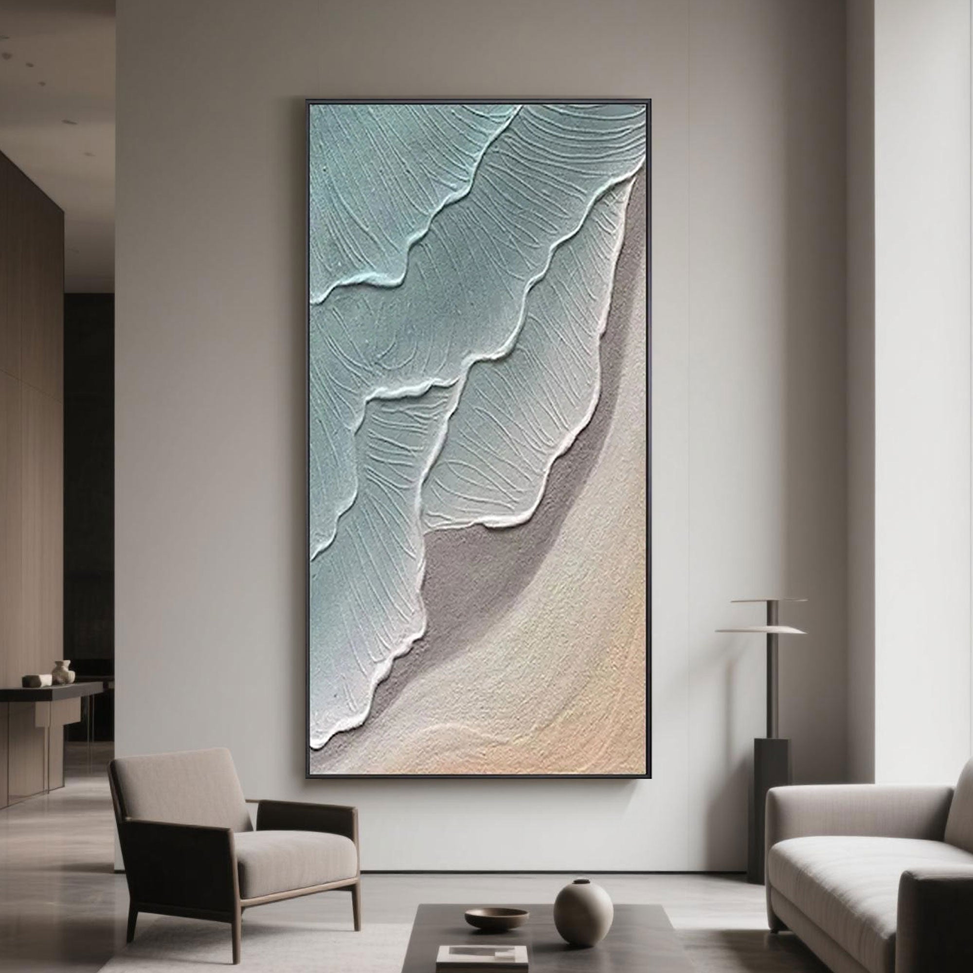 Stylish modern lounge area displaying vertical ocean-themed abstract painting, featuring soothing blue and beige textured waves.