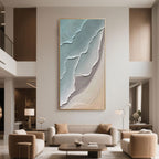 Spacious and refined double-height living area enhanced by large vertical abstract ocean art, characterized by calming blue and beige textures.