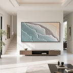 Modern living room featuring minimalist ocean-themed abstract wall art, showcasing hand-painted blue and beige wave textures on canvas.