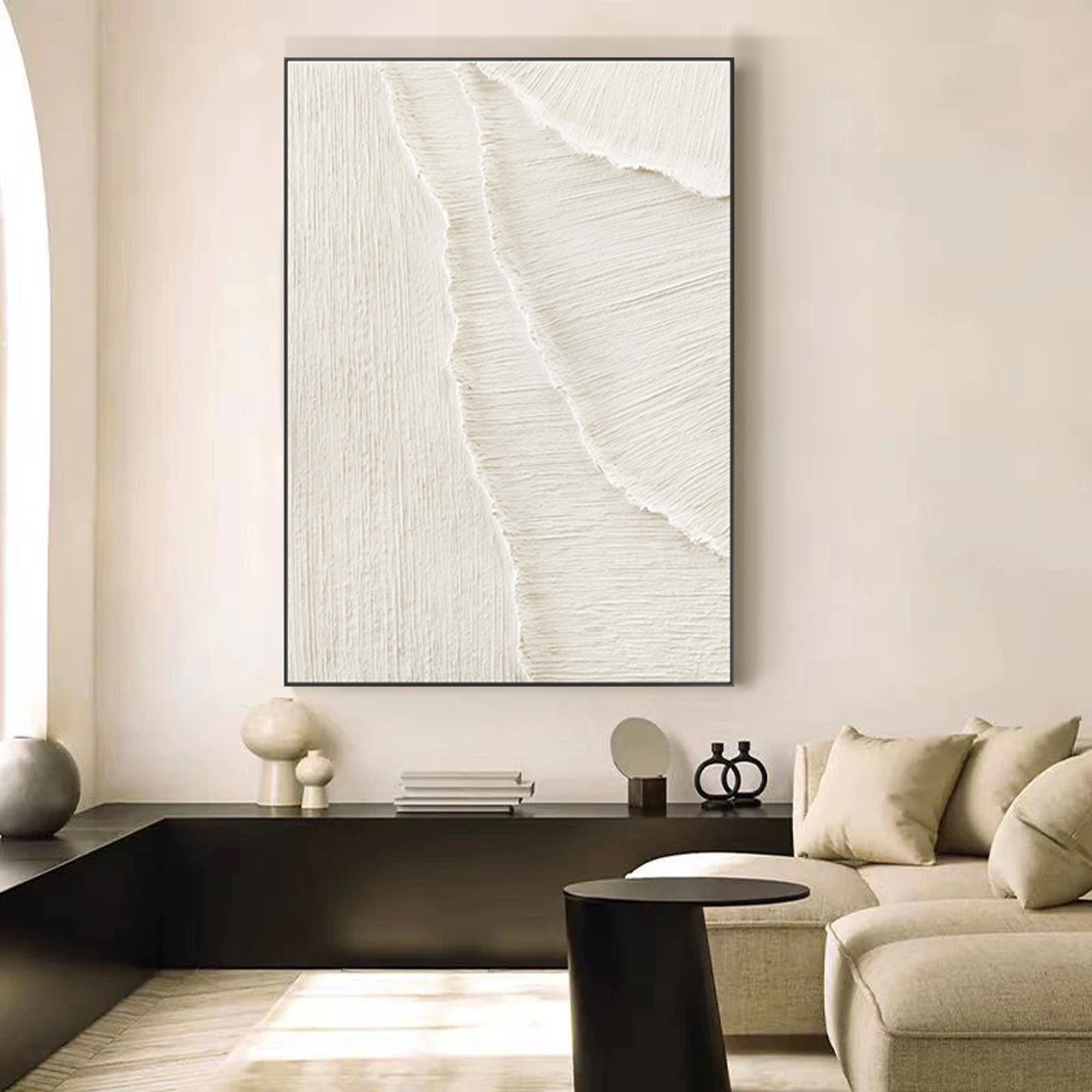 Whitecaps beige and white textured painting in a black frame above a modern console.