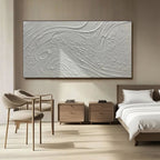 Minimalist textured art in a serene dining room setting with natural light.