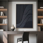 Black 3D canvas art in gold frame displayed above desk with shelves backdrop.