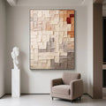 Minimalist geometric abstract canvas painting with textured squares in neutral/red tones, modern living room display at Lumi Gallery