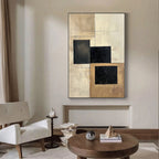 Vertical beige and black geometric canvas art on gallery wall.