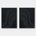 Minimalist black wall art featuring curved reliefs and vertical textures.