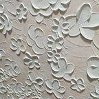Close-up of the white palette knife sculpted floral details on the painting.