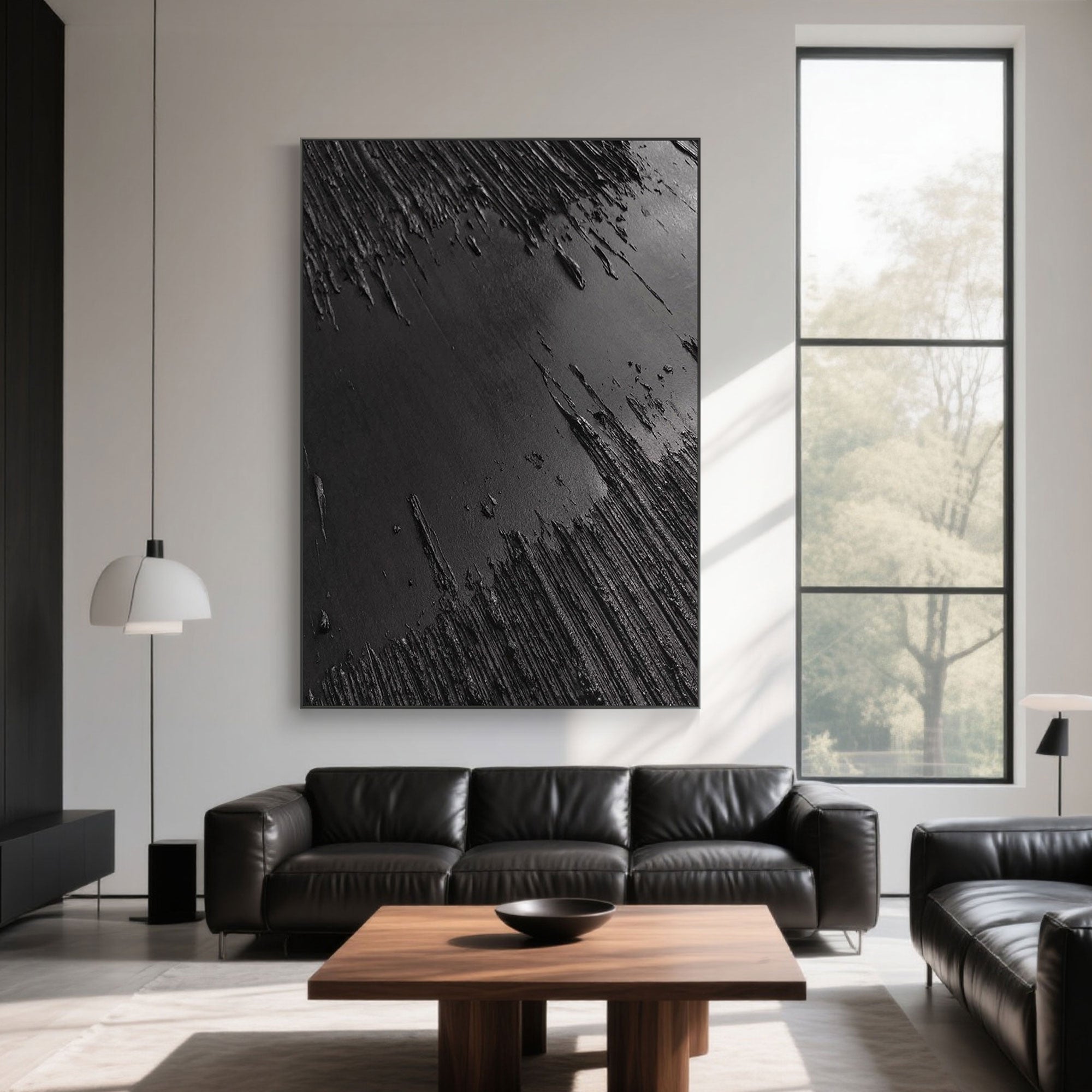 Minimalist black canvas art displayed above a leather sofa in a living room.
