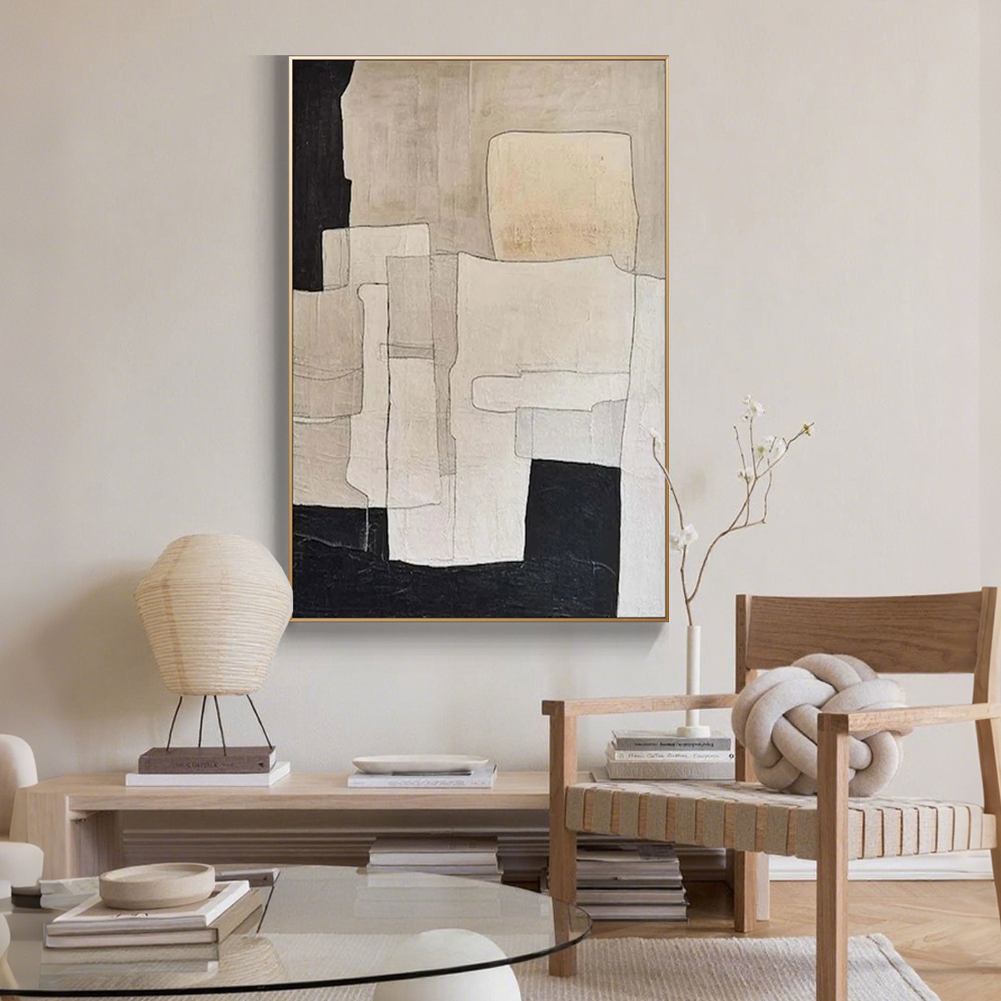 Close-up of beige and black geometric canvas art in minimalist room.