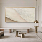 Minimalist Abstract Wave Wall Art – Soft Crest: soft beige and cream textured waves, gold frame, displayed in modern living room with neutral tones and brass accents.