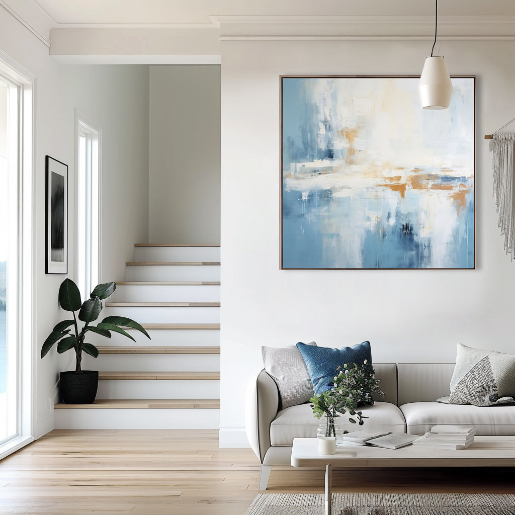 Modern living room featuring abstract blue landscape canvas art above a white sofa.