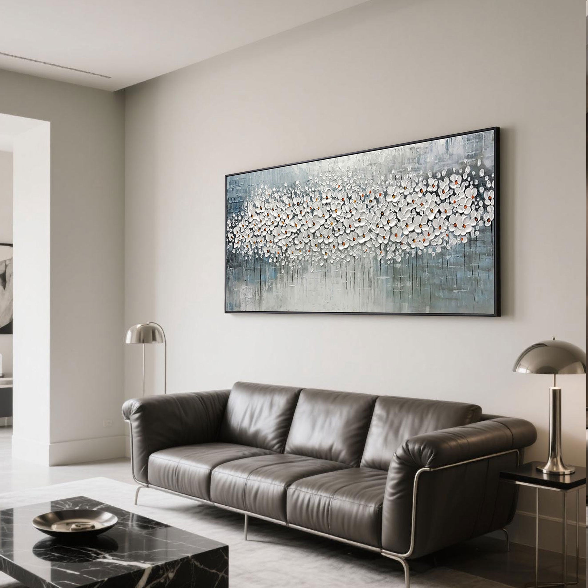 Horizontal floral wall art in a modern living room with a black leather sofa.