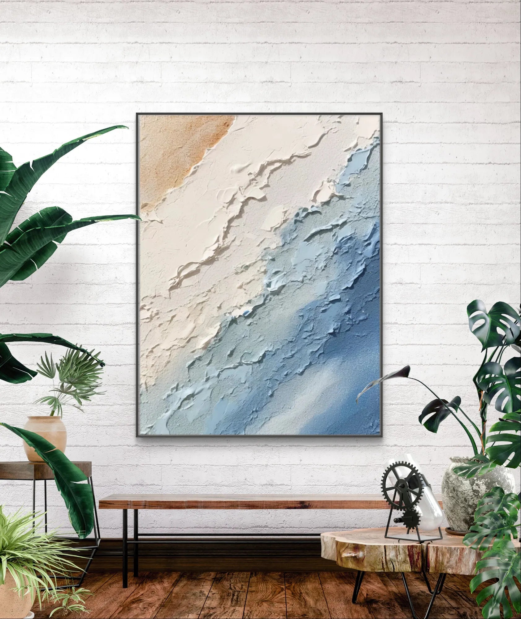 Modern abstract ocean painting in a black frame on a brick wall