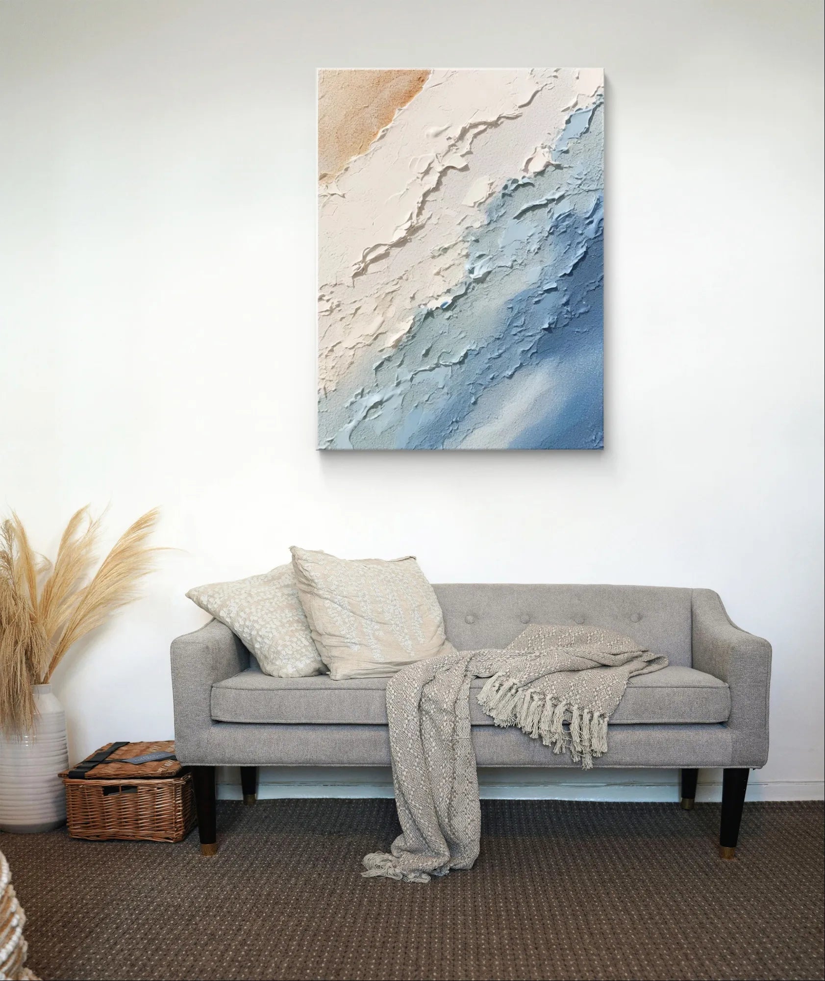 Modern abstract ocean painting above a gray sofa with pillows