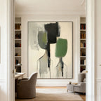 Modern abstract portrait wall art 'Distance' with two figures in black, green, and gray on a beige canvas, displayed in a bright room with built-in bookshelves and a desk.