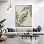 Lumi Gallery modern minimalist botanical canvas art with banana leaves, textured details, mounted on white wall above light gray sofa