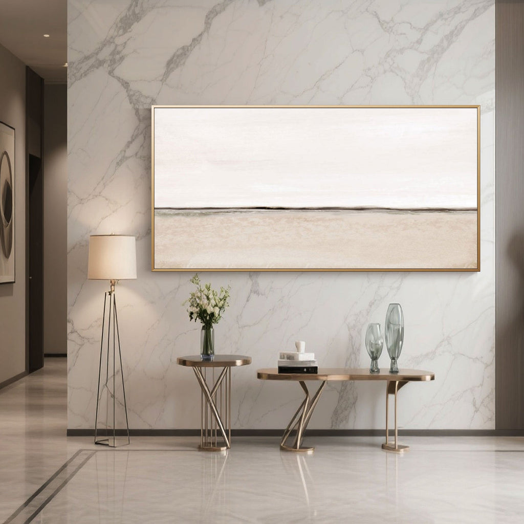 Beige canvas art in gold frame displayed above console table in entryway